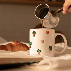 A white mug with a little potted plant design